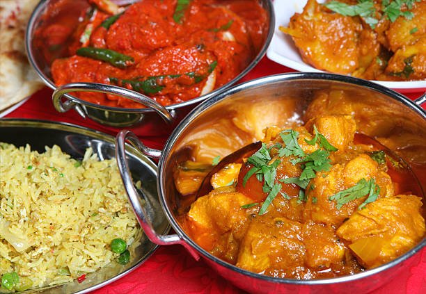 "Indian curry meal with rice, nan and begetables"